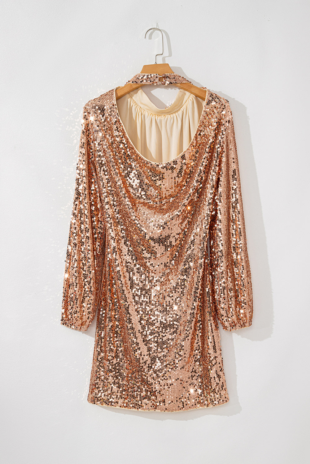 Mini-robe dorée à sequins, manches longues et dos découpé